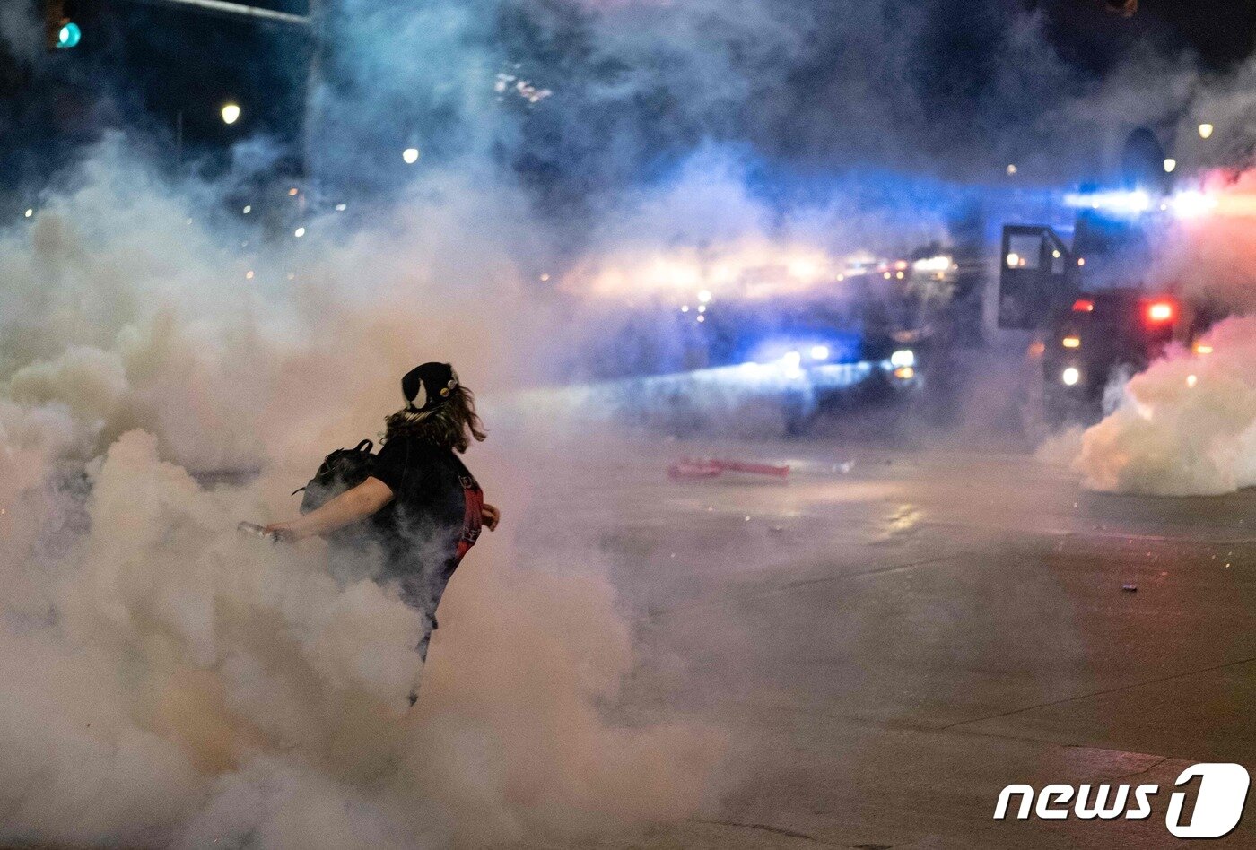 본문 이미지 - 30일(현지시간) 미시간주 디트로이트에서 비무장 흑인 남성 조지 플로이드의 백인 경찰 가혹 행위로 숨진 사건에 항의하는 시위대가 경찰을 향해 최루탄을 되던지고 있다. ⓒ AFP=뉴스1