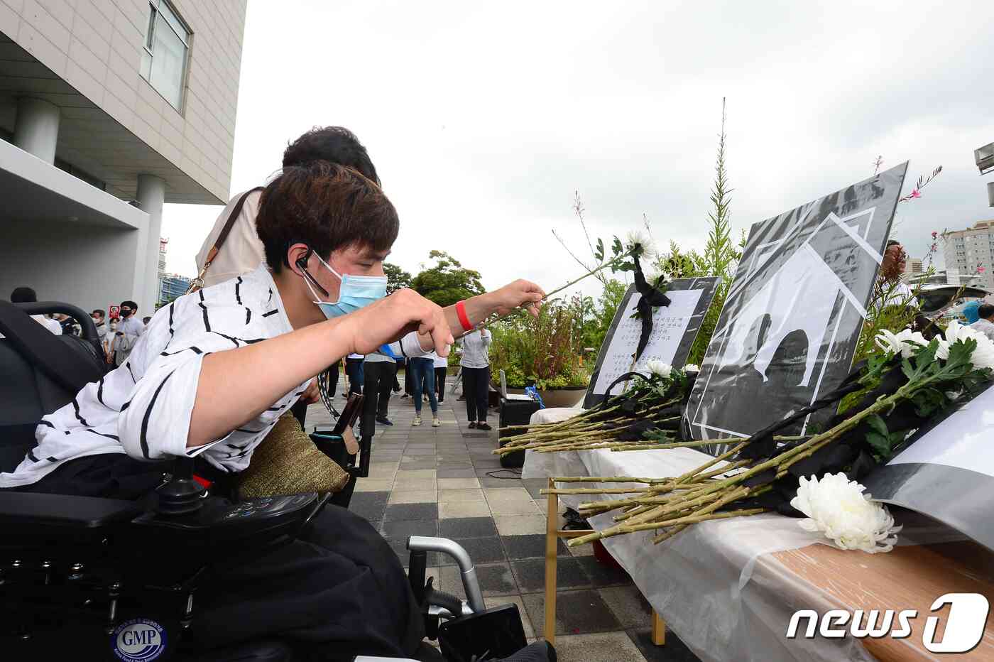 11일 오전 광주 서구 광주시청 앞에서 광주장애인부모연대 주최로 열린 '발달장애인 청년과 그 엄마를 기리며, 보고 싶습니다 사랑합니다…그리고 미안합니다' 추모제에서 한 참가자가 헌화하고 있다. 2020.6.11/뉴스1 © News1 한산 기자