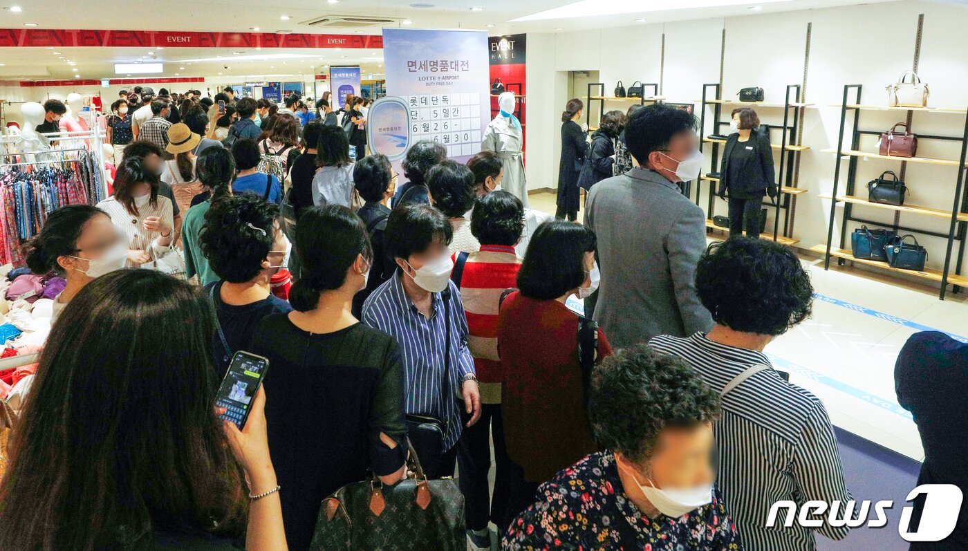 본문 이미지 - 26일 오전 서울 롯데백화점 영등포점에서 열린 면세 명품 대전에서 번호표를 받지 못한 고객들이 행사장을 구경하고 있다. 2020.6.26/뉴스1 ⓒ News1 안은나 기자
