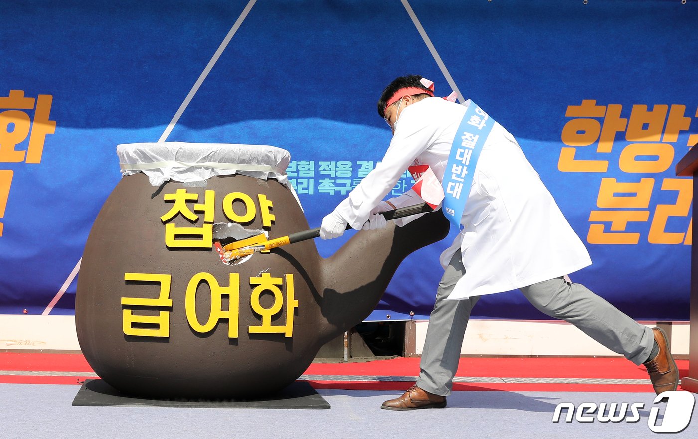 본문 이미지 - 대한의사협회 회원이 28일 오후 서울 청계천 한빛광장에서 첩약 급여화 건강보험 적용 결사반대 및 건강보험 분리를 촉구하며 퍼포먼스하고 있다. 보건복지부는 지난 9일 건강보험정책심의위원회 소위원회 1차 회의에 첩약 급여화 시범사업 관련 안을 제출했다. 시범사업은 뇌혈관질환 후유증, 안면신경마비, 월경통 등에 사용하는 첩약에 건강보험 급여를 적용하는 게 주된 내용으로, 세부 내용은 다음 달 건정심 회의에서 확정된다. 2020.6.28/뉴스1 ⓒ News1 이승배 기자