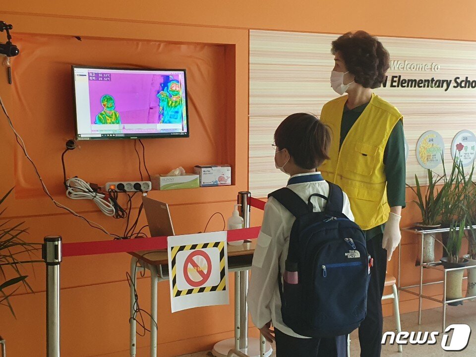 본문 이미지 - 3일 오전 서울 용산구 서울이태원초등학교에서 한 학생이 열화상카메라를 통해 발열체크 중이다. ⓒ 뉴스1/정혜민 기자