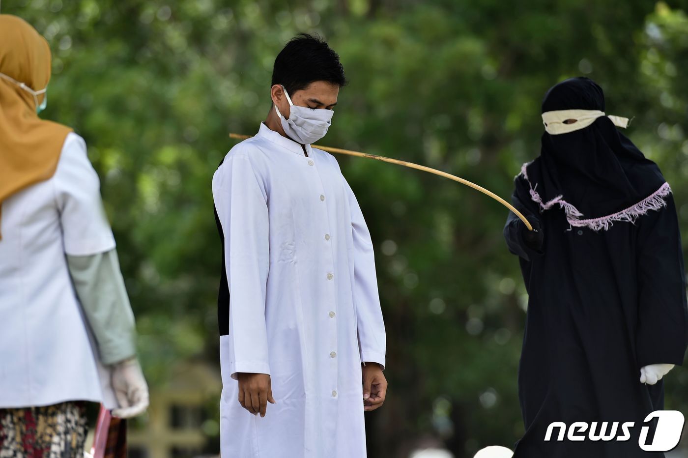 본문 이미지 - 혼전 성관계를 맺었다가 지역 당국에 적발된 한 남성이 지난 5일 인도네시아 아체주에서 공개적으로 회초리를 맞고 있다. (Photo by CHAIDEER MAHYUDDIN / AFP) ⓒ AFP=뉴스1 ⓒ News1 이종덕 기자