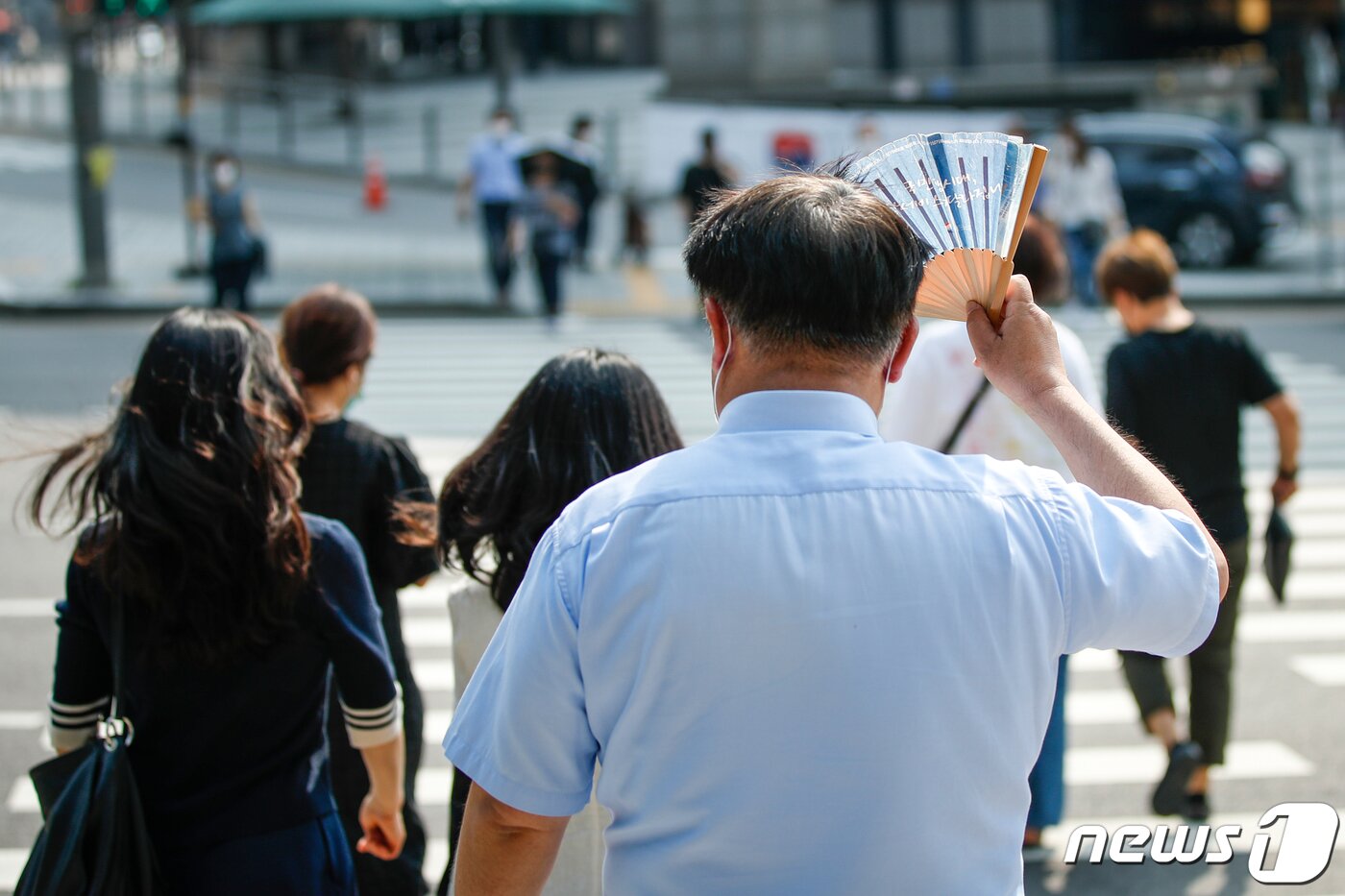 본문 이미지 -  8일 오후 서울 중구 회현사거리에서 한 시민이 부채로 햇빛을 가린 채 걸어가고 있다./뉴스1 ⓒ News1 안은나 기자