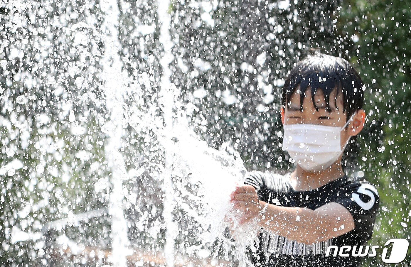 본문 이미지 - 전국적으로 폭염주의보가 내려진 9일 오후 서울 마포구의 한 공원에 설치된 분수대에서 마스크를 쓴 어린이가 시원한 물줄기를 맞으며 더위를 식히고 있다./뉴스1 ⓒ News1 이동해 기자