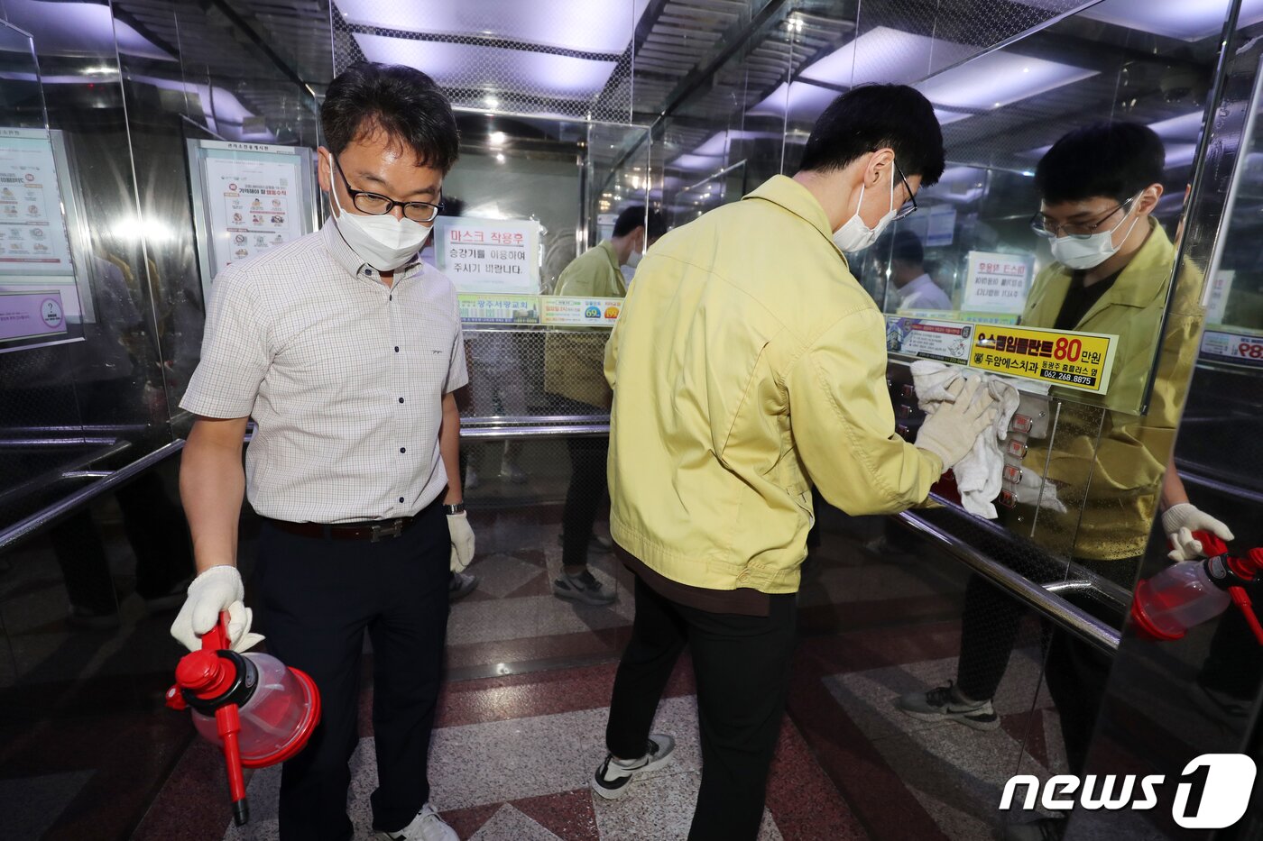 본문 이미지 - 엘리베이터 내부를 소독하고 있는 모습./뉴스1 ⓒ News1 황희규 기자