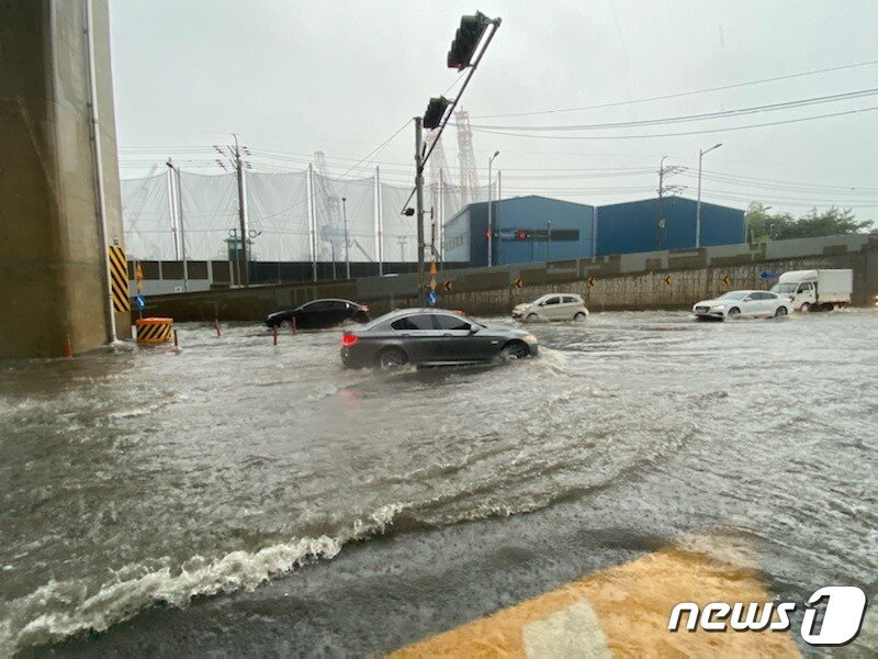 본문 이미지 - 10일 오전 호우경보가 내린 부산 영도구의 한 아파트 앞 도로가 침수돼 차량들이 통행에 어려움을 겪고 있다. (부산소방본부 제공)2020.7.10/뉴스1 ⓒ News1