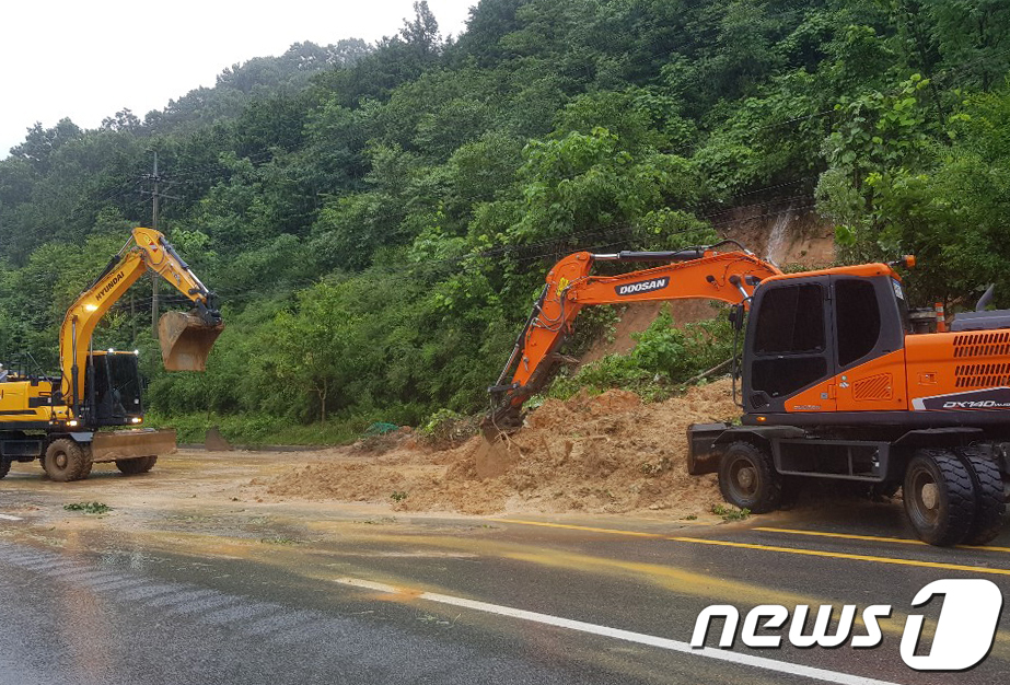 (담양=뉴스1) 황희규 기자 = 광주와 전남지역에 많은 비가 내린 13일 전남 담양군 월산면 한 도로에서 토사가 유실돼 군청 관계자들이 굴삭기를 이용해 토사를 제거하고 있다.(담양 …