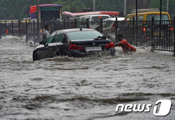 인도 뭄바이에서 한 남성이 물에 빠진 자동차를 끌어내고 있다. © 로이터=뉴스1