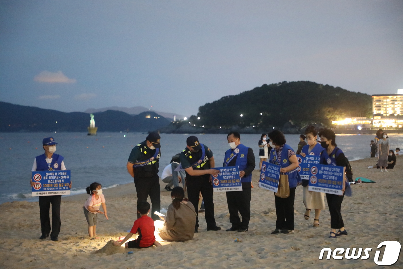 (부산=뉴스1) 박세진 기자 = 부산 해운대구청과 해운대경찰서, 주민단체 관계자들이 18일 오후 해운대해수욕장 일대에서 마스크 착용과 취식금지 계도활동을 벌이고 있다.2020.7. …