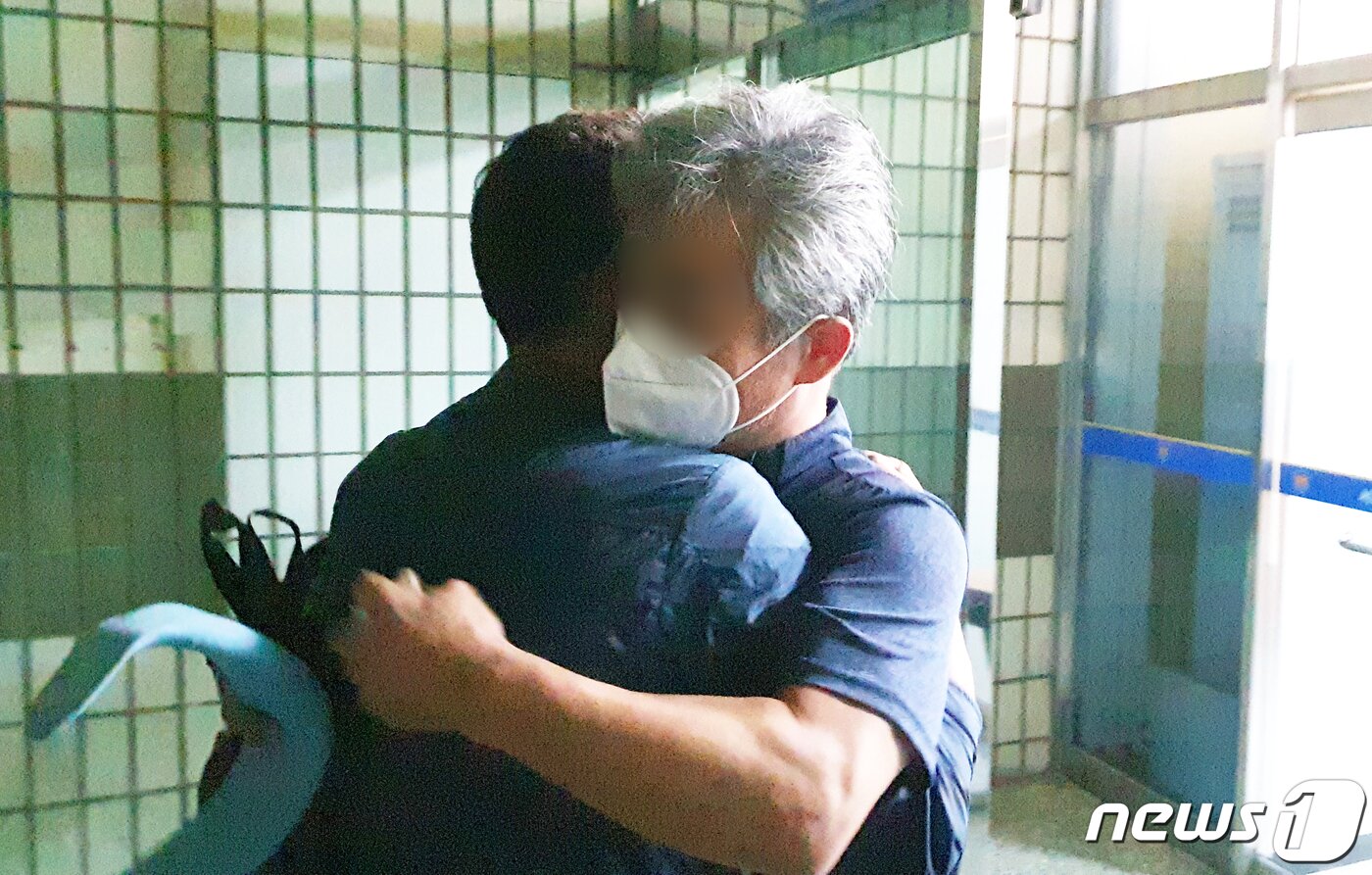본문 이미지 - 문재인 대통령을 향해 신발을 벗어 던진 뮤지컬 극단 '긍정의 힘' 정창옥 단장(57, 오른쪽)이 19일 오후 법원의 영장이 기각되면서 서울 영등포경찰서 유치장을 나와 지지자와 포옹하고 있다. 서울 남부지법 김진철 영장전담 부장판사는 이날 오후 11시께 "증거를 인멸하거나 도망할 염려가 있다고 보기 어렵고, 구속의 상당성 및 필요성이 부족하다＂면서 구속영장을 기각했다. 2020.7.19/뉴스1 ⓒ News1 황덕현 기자