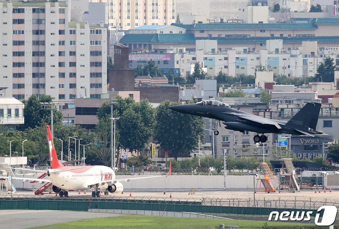 본문 이미지 - 대구공군기지에 F-15K 전투기가 착륙하고 있다. 대구국제공항은 K-2 공군기지와 활주로를 같이 쓰는 민간·군사 공항이다. 전투기 아래 민항기가 보인다. 2020.7.2 ⓒ 뉴스1 공정식 기자