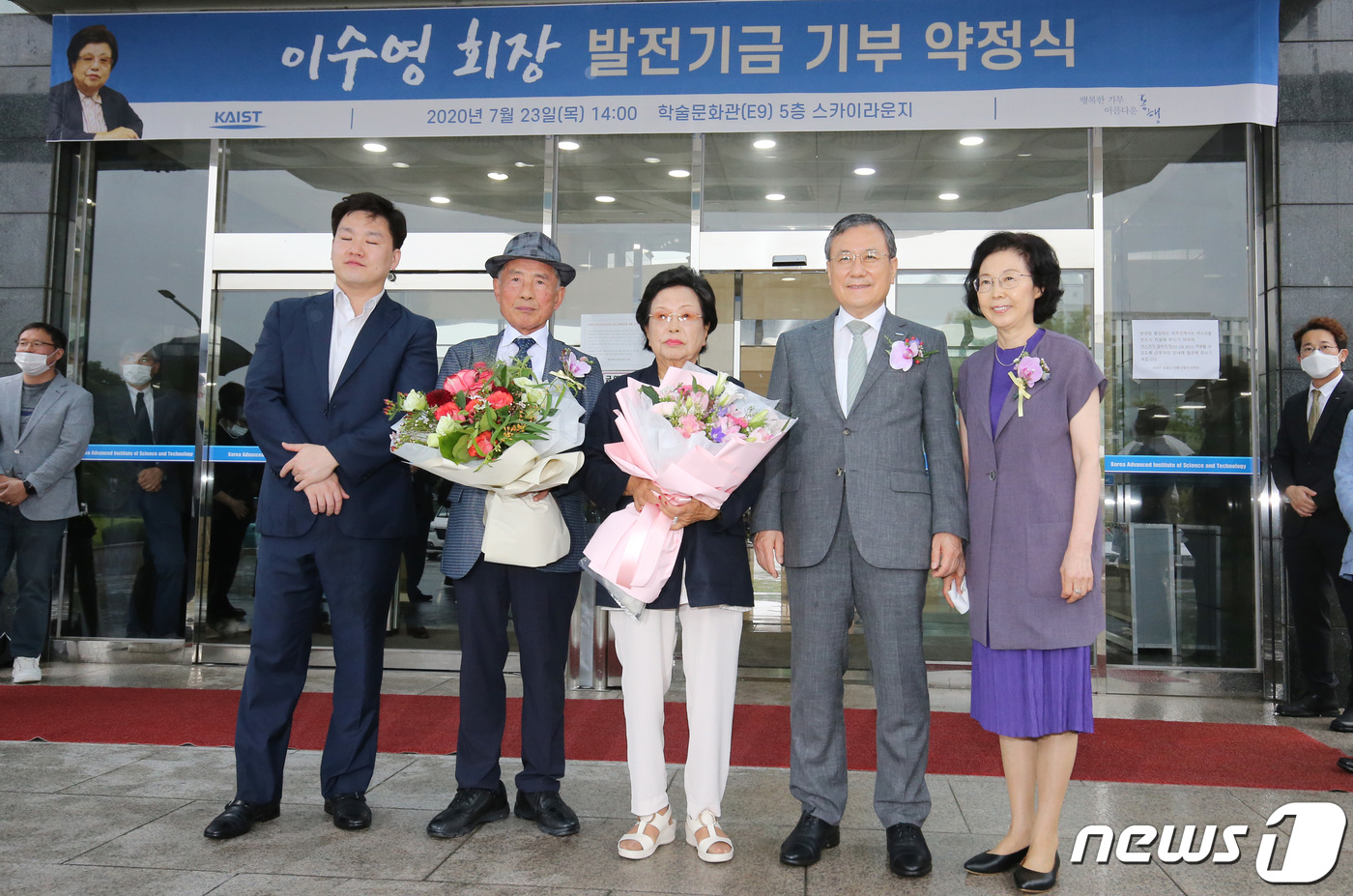 (대전=뉴스1) 김기태 기자 = 이수영 광원산업 회장(가운데) 내외가 23일 오후 대전 유성구 한국과학기술원(KAIST)에서 열린 발전기금 기부 약정식에 앞서 감사의 꽃다발을 받고 …