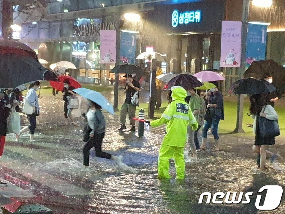 본문 이미지 - 부산에 23일 오후 8시를 기점으로 호우 경보가 발효된 가운데 시간당 50mm 이상의 많은 비가 내리면서 침수 피해가 잇따르고 있다. 사진은 부산 부전동 삼정타워 앞에서 현장 관리에 나선 교통경찰관 모습.(부산경찰청 제공)2020.7.23/뉴스1 ⓒ News1 박세진 기자