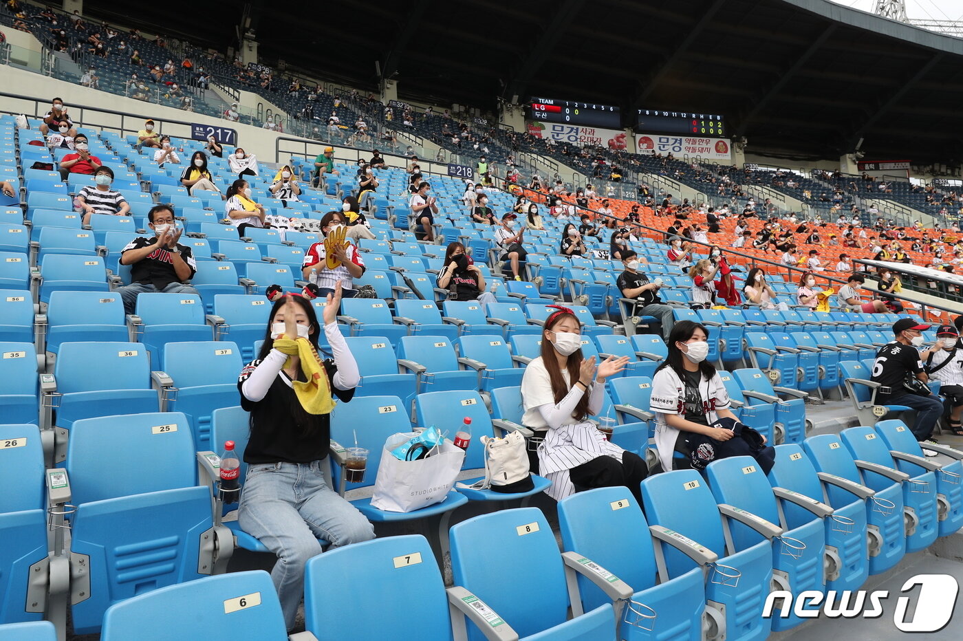본문 이미지 - 신종 코로나바이러스 감염증(코로나19) 사태로 닫혔던 관중석 출입구가 열렸다. 프로야구 관중 입장 첫 날인 26일 서울 잠실야구장에서 열린 KBO리그 두산과 LG의 경기를 찾은 야구팬들이 관중석에 띄엄띄엄 앉아 열띤 응원을 하고 있다. 2020.7.26/뉴스1 ⓒ News1 박지혜 기자