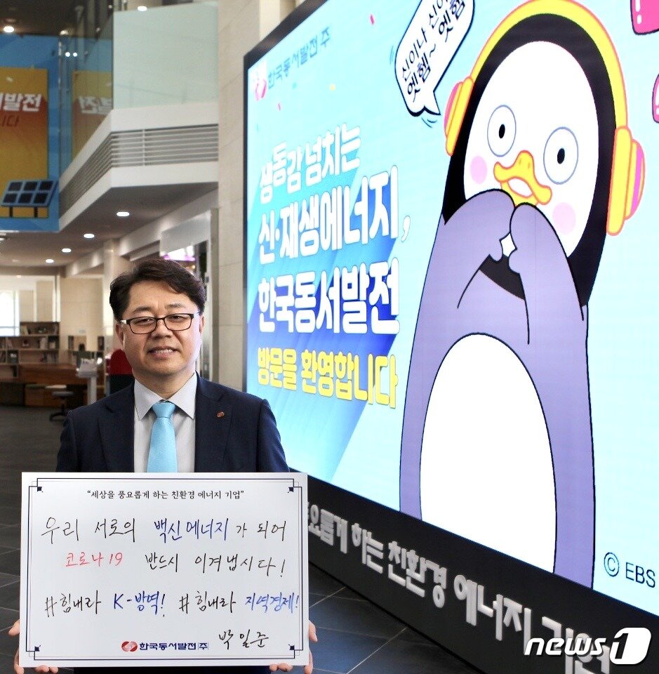 본문 이미지 - : 박일준 동서발전 사장이 울산 본사 사옥 1층 로비에 설치된 LED 전광판 앞에서 코로나19 극복 메시지를 담은 피켓(손팻말)을 들고 사진을 촬영하고 있다. (동서발전 제공) ⓒ 뉴스1