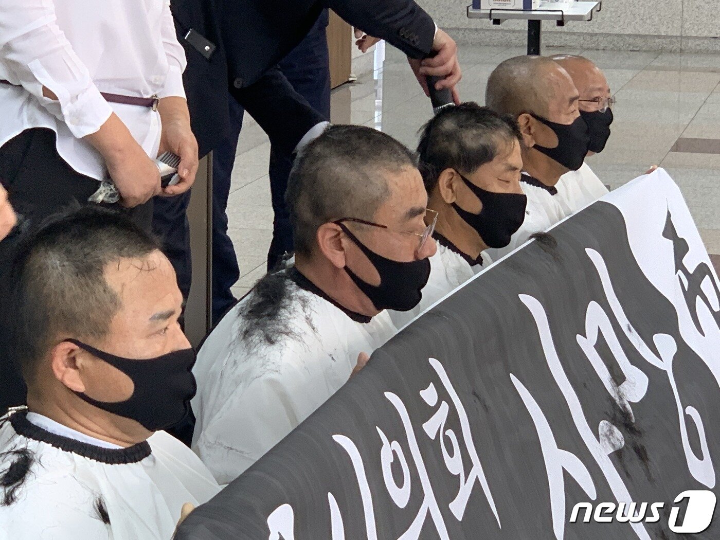 본문 이미지 - 7일 충북 충주시의회 미래통합당 소속 의원들이 더불어민주당 의원의 후반기 원 구성 독식에 반발해 의회 본회의장 앞에서 삭발을 하고 있다.2020.7.7/ⓒ 뉴스1