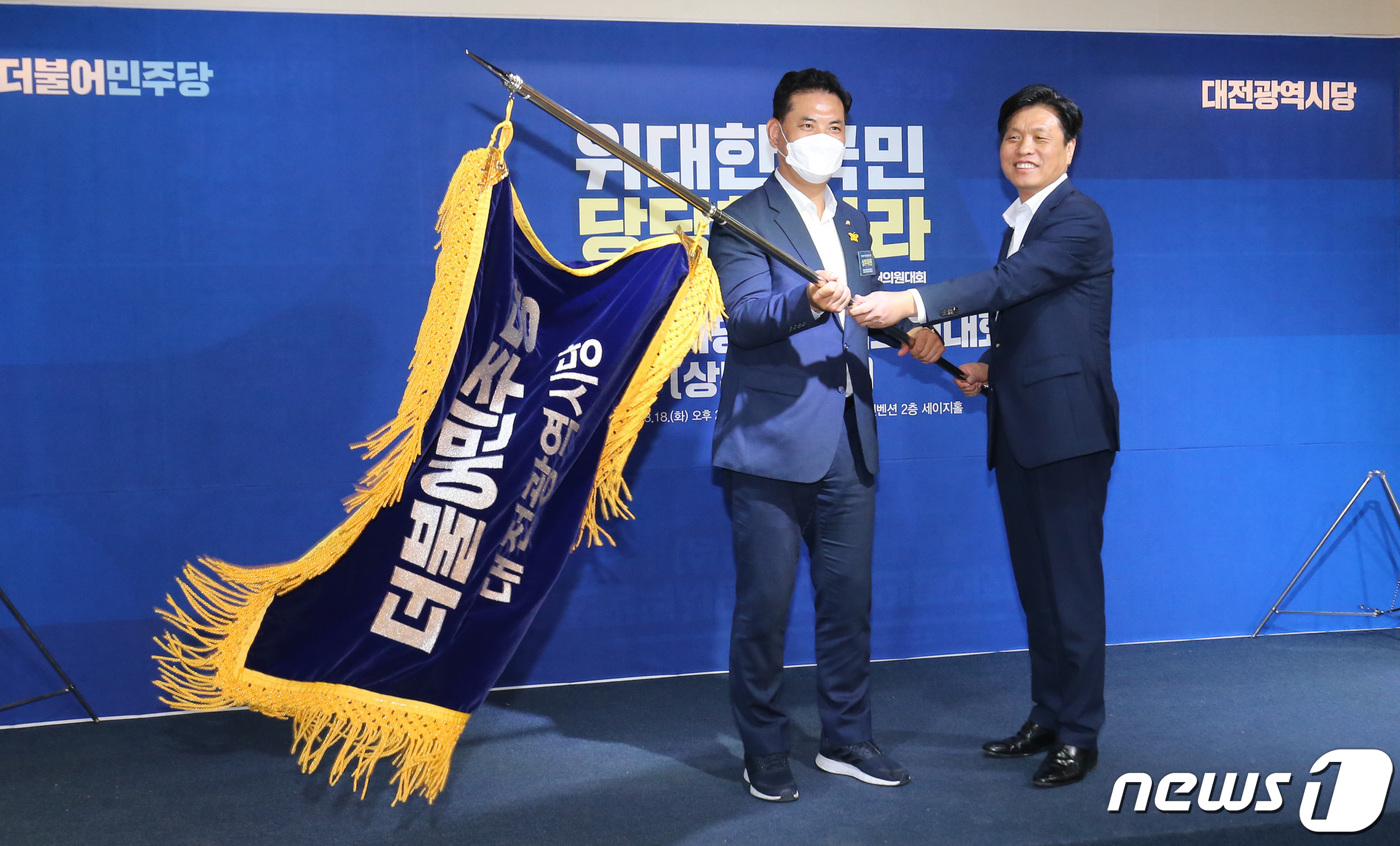 (대전=뉴스1) 김기태 기자 = 18일 오후 대전 서규 오페라웨딩컨벤션에서 열린 더불어민주당 대전시당 정기대의원대회에서 박영순 신임 위원장이 시당기를 흔들고 있다. 2020.8.1 …