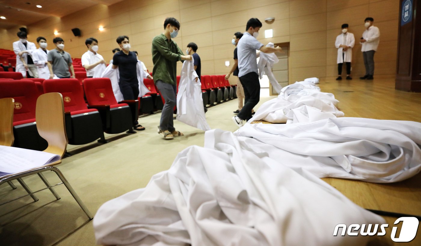 본문 이미지 - 정부의 의과대학 정원 확대 등에 반대하는 전공의들이 23일 오전 서울 노원을지병원에서 의사 가운을 벗는 퍼포먼스를 벌이고 있다. 이날 의과대학 정원 확대 등 정부 정책에 반대를 표시한 모든 연차의 전공의들이 전국 병원 곳곳에서 의사 가운을 벗는 퍼포먼스와 함께 무기한 파업에 들어갔다. 대한전공의협의회에 따르면 지난 21일 인턴과 4년차 레지던트, 22일 3년차 레지던트에 이어 이날 1년차와 2년차 레지던트까지 파업에 참여하면서 모든 전공의가 업무에서 손을 뗐다. 2020.8.23/뉴스1 ⓒ News1 박지혜 기자