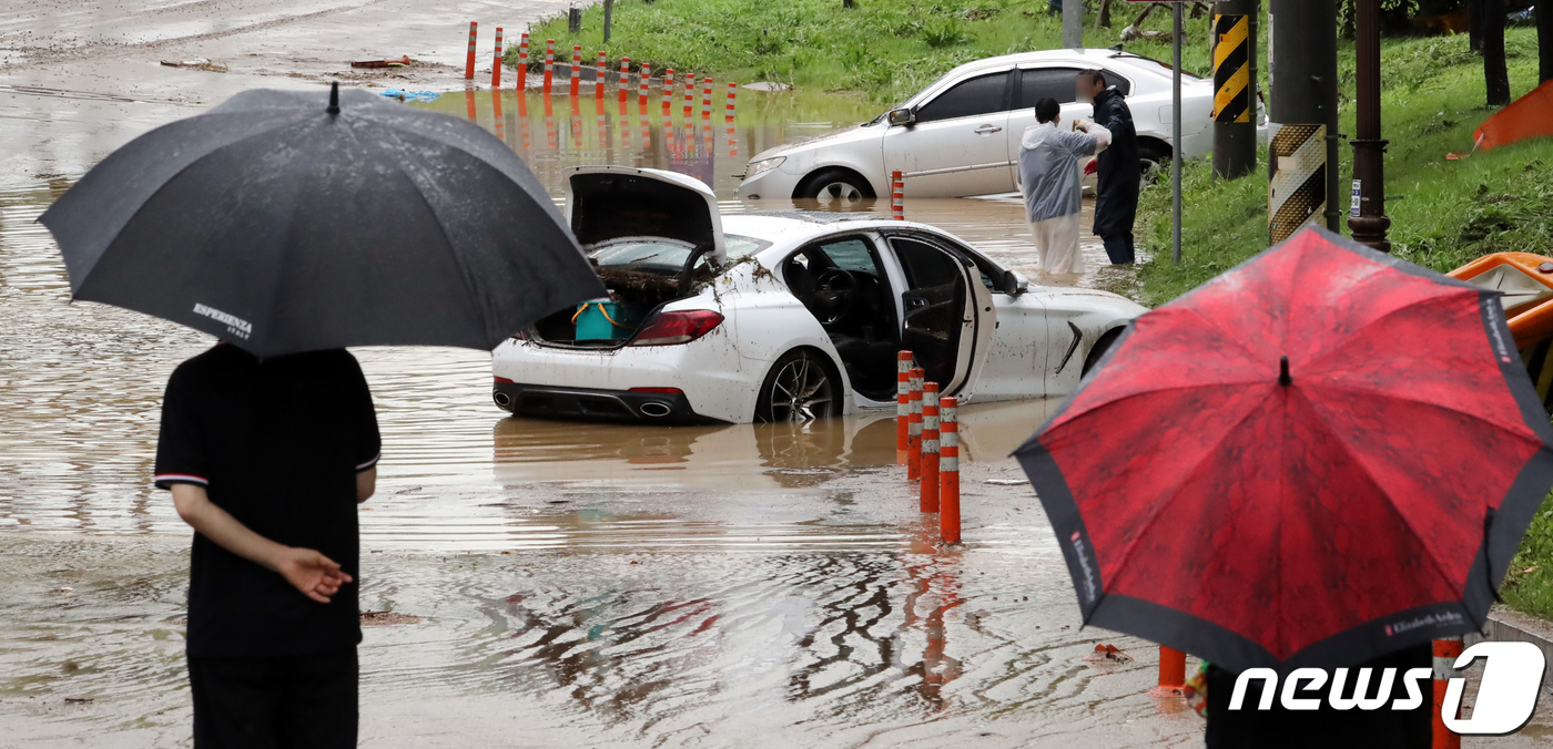 (천안=뉴스1) 장수영 기자 = 경기도와 충청지역에 많은 비가 내리며 곳곳에서 피해가 발생한 3일 충남 천안시 서북구 신방동에서 갑자기 불어난 물을 미쳐 피하지 못한 차량이 물에 …