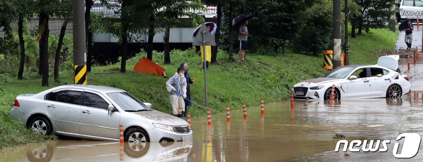 (천안=뉴스1) 장수영 기자 = 경기도와 충청지역에 많은 비가 내리며 곳곳에서 피해가 발생한 3일 충남 천안시 서북구 신방동에서 갑자기 불어난 물을 미쳐 피하지 못한 차량이 물에 …