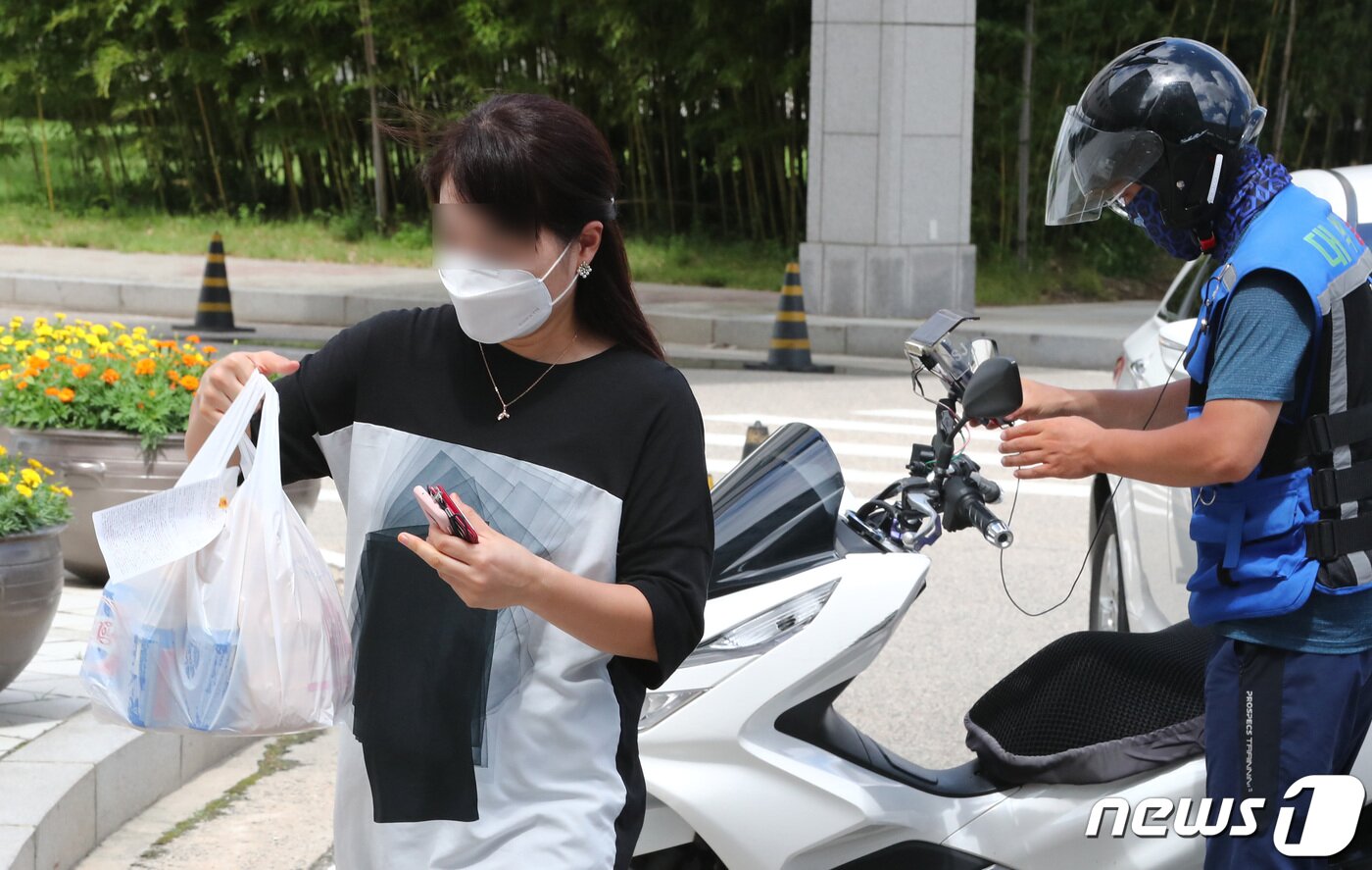 본문 이미지 - 정부대전청사 공무원들이 31일 청사 출입구에서 배달음식을 받아가고 있다. 신종 코로나바이러스 감염증(코로나19) 확산으로 배달음식 및 도시락으로 점심을 해결하는 직장인이 늘어나고 있다 2020.8.31/뉴스1 ⓒ News1 김기태 기자