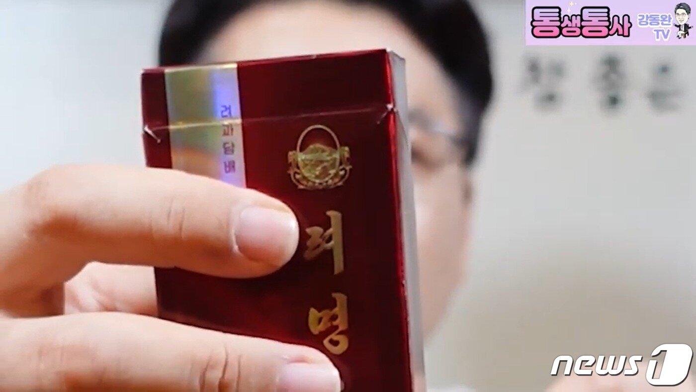 본문 이미지 - 빨간색 담뱃갑에 담긴 북한의 '려명' 담배. 3종류의 려명 담배 중 가장 저렴한 제품으로 알려져 있다.  ('통생통사 강동완 TV' 갈무리)  ⓒ 뉴스1