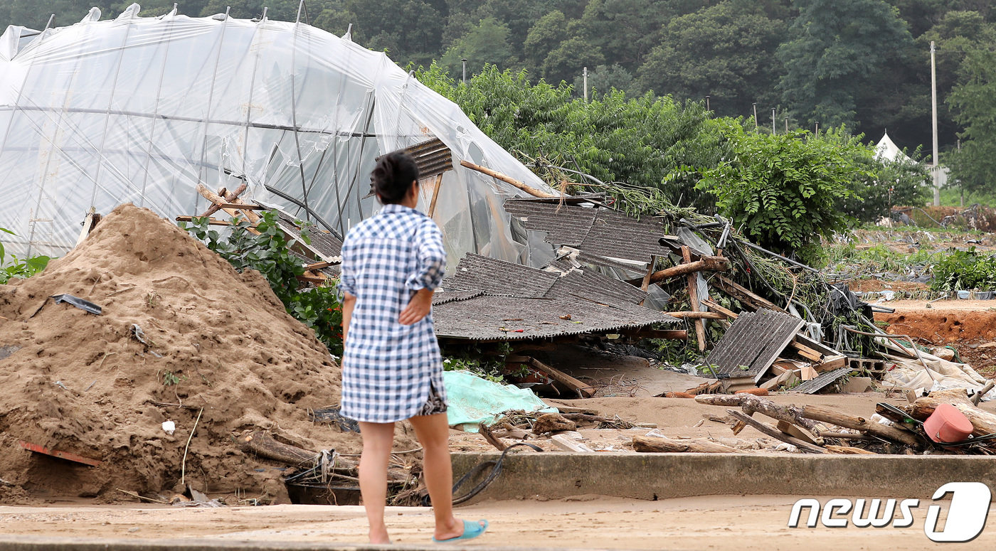 (이천=뉴스1) 박지혜 기자 = 4일 경기도 이천시 율면 산양저수지 일대 마을에서 주민들이 토사가 덮친 수해현장을 바라보고 있다.지난 2일 기록적으로 내린 폭우로 산양저수지 둑이 …