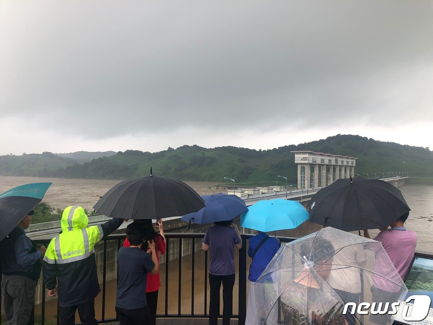 본문 이미지 - 저지대 주민 대피령이 발령된 5일 오후 4시께 최북단 군남댐 앞에서 물살 구경 나온 사람들. /ⓒ 뉴스1