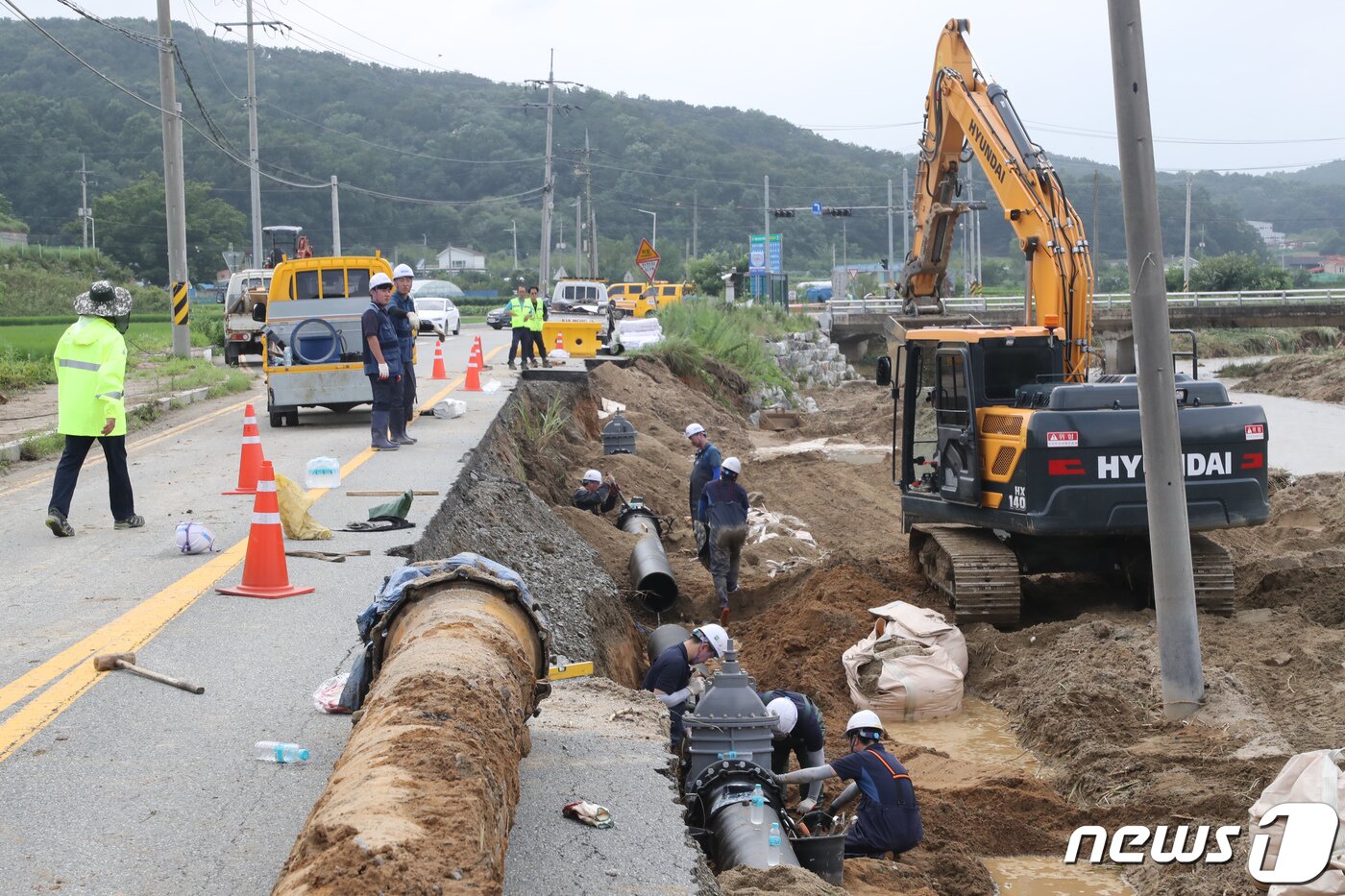 본문 이미지 - 5일 충남 천안시 성남면 승천천 용원교 앞 도로가 지난 폭우로 유실되면서 공업용 상수도관이 파열, 수자원공사 및 업체 관계자들이 긴급복구 작업을 하고 있다. 2020.8.5/뉴스1 ⓒ News1 장수영 기자