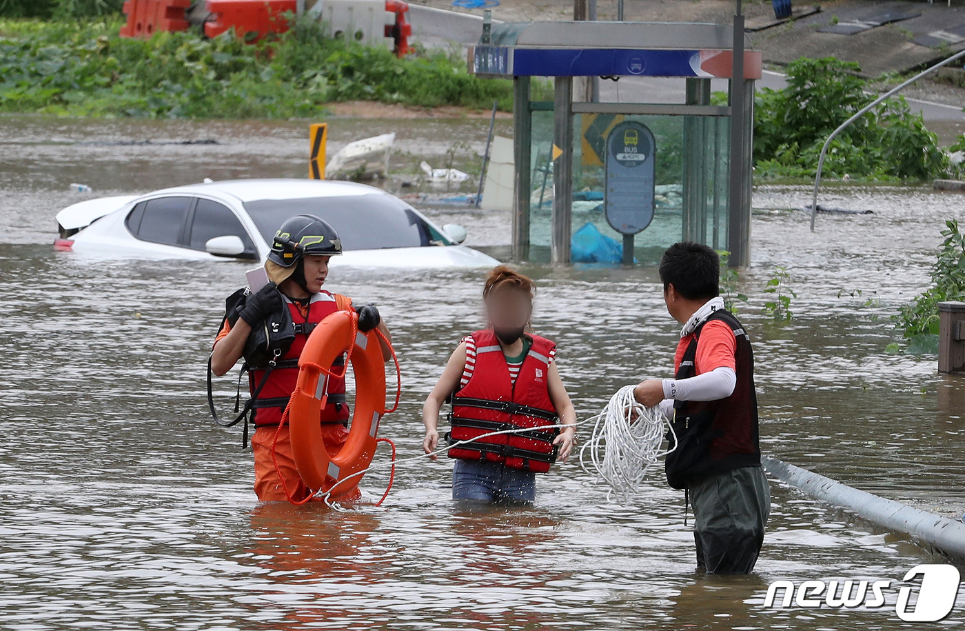 (파주=뉴스1) 이동해 기자 = 6일 오전 임진강 인근의 경기도 파주시 파평면 율곡1리에서 한 주민이 차량을 타고 마을을 건너던 중 고립돼 119 구조대원에게 구조되고 있다. 20 …
