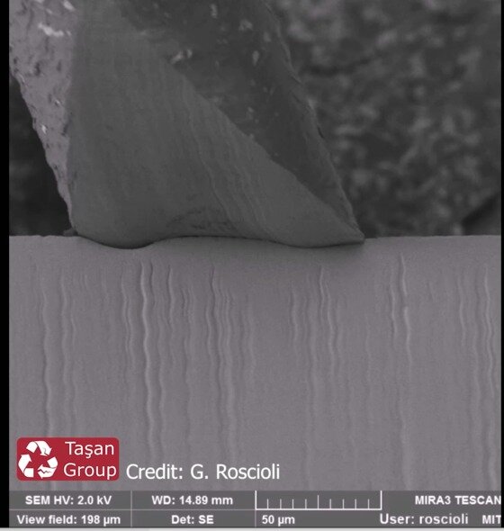 본문 이미지 - 연구진이 촬영한 면도과정 전자현미경 사진, 면도날(아래쪽)과 체모가 만나는 부분이 균일하게 마모되지 않고 일부분이 먼저 흡집이나 패여있다. (지안루카 로시올리(Gianluca Roscioli) 제공) 2020.08.06 /뉴스1