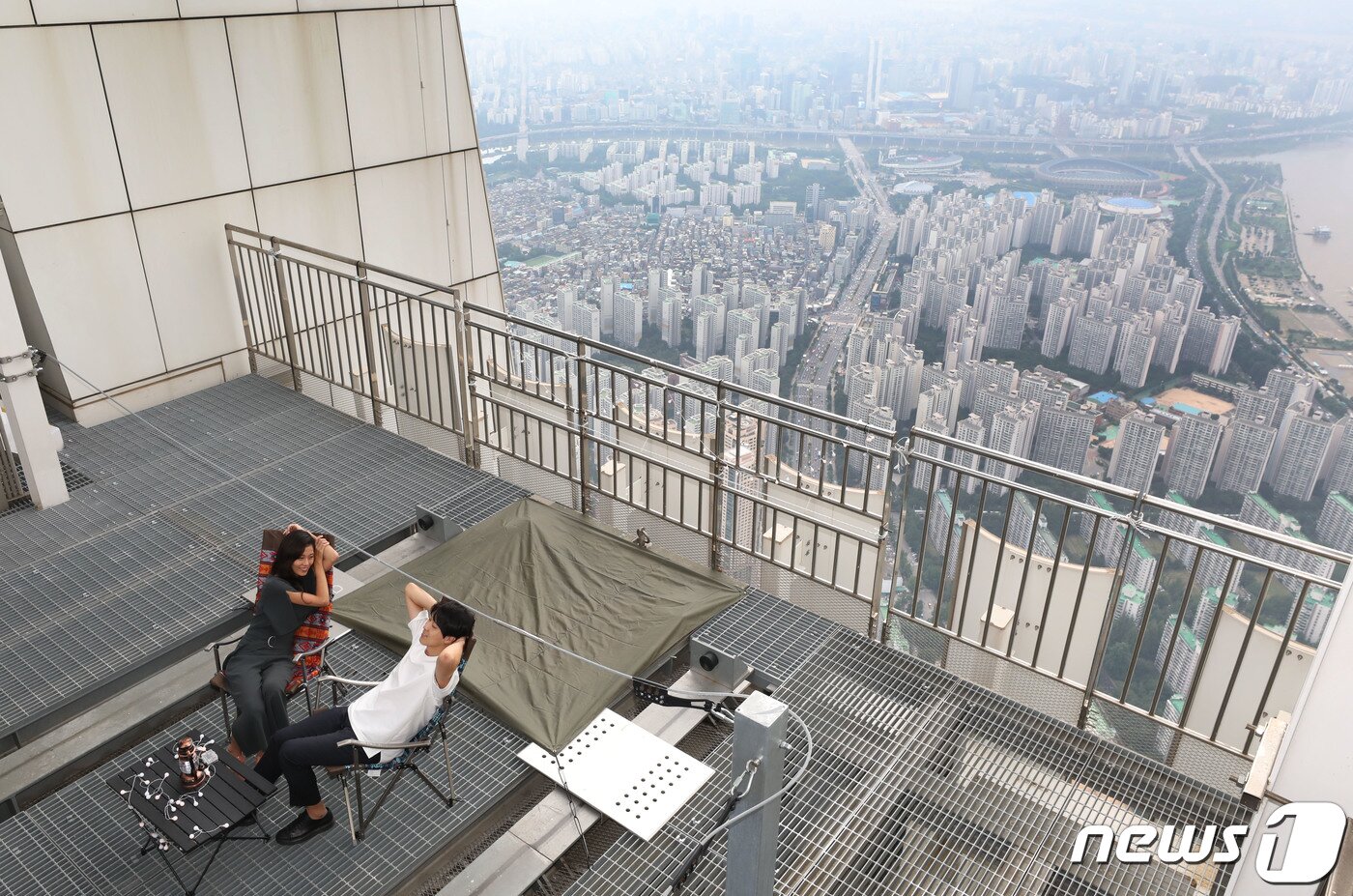 본문 이미지 - 7일 서울 잠실 롯데월드타워 123층 534m 높이에 마련된 '비박존'에서 유튜버 윤재원씨와 배희준씨가 캠핑을 즐기고 있다. 2020.8.7/뉴스1 ⓒ News1 임세영 기자