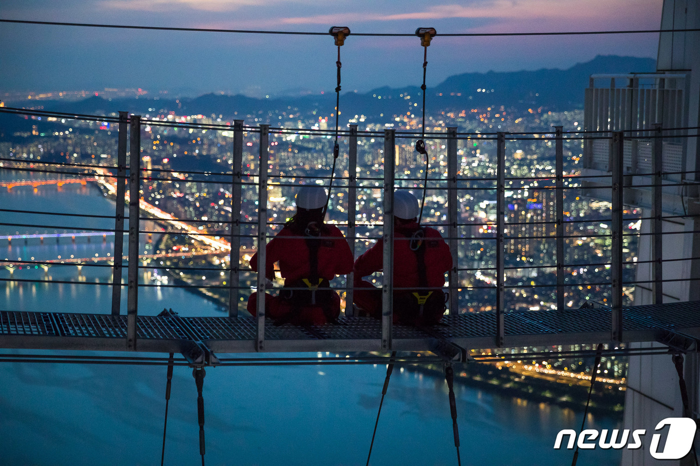 (서울=뉴스1) = 롯데월드타워 전망대 서울스카이(대표 최홍훈)를 찾은 시민들이 일몰 후 서울의 야경과 함께 지상 541m 상공에서 ‘스카이브릿지 투어’를 즐기고 있다.스카이브릿지 …