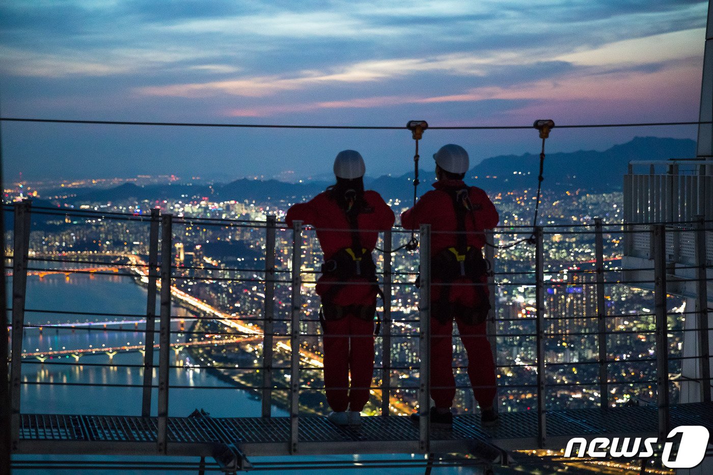 본문 이미지 - 롯데월드타워 전망대 서울스카이를 찾은 시민들이 일몰 후 서울의 야경과 함께 지상 541m 상공에서 ‘스카이브릿지 투어’를 즐기고 있다. (롯데월드 제공) 