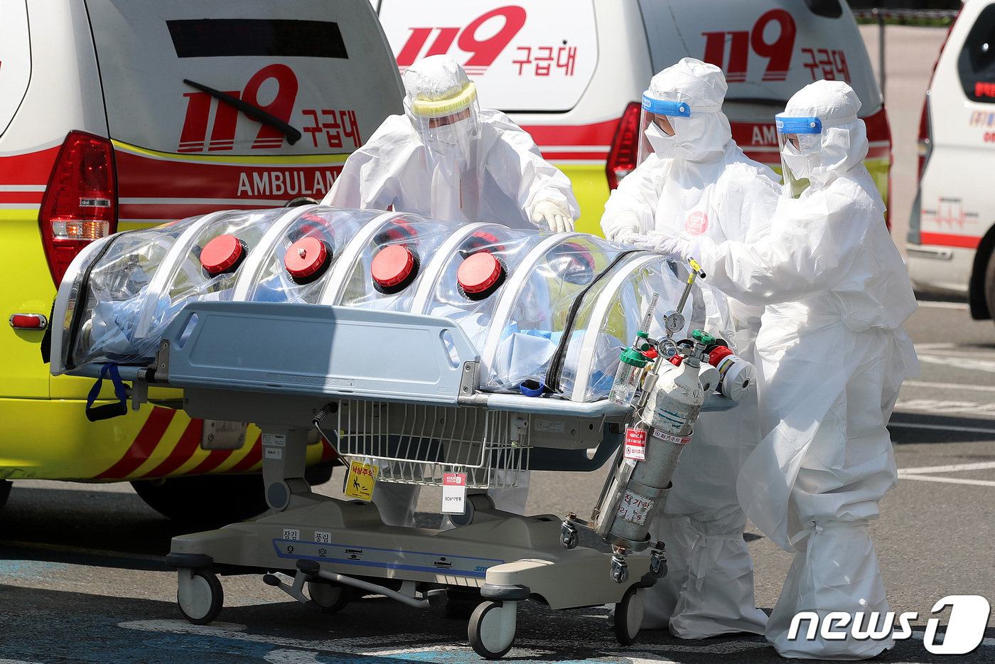 (대구=뉴스1) 공정식 기자 = 4일 오전 대구 중구 삼덕동 경북대학교병원에서 119구급대와 병원 의료진이 이송된 신종 코로나바이러스 감염증(코로나19) 확진 환자를 옮기기 위해 …