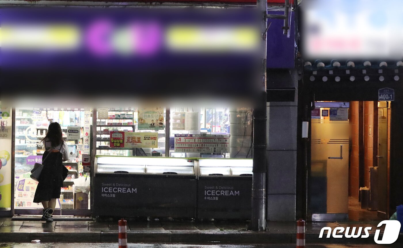 본문 이미지 - 사회적 거리두기 2.5단계로 주점과 음식점이 영업을 조기 종료하면서 심야 먹거리 수요가 편의점으로 쏠리고 있다. 7일 저녁 9시경 한 시민이 서울 시내 편의점에 들어서고 있다. 오른쪽으로는 영업이 종료된 음식점이 한산한 모습을 보이고 있다. 2020.9.7 /뉴스1 ⓒ News1 이성철 기자
