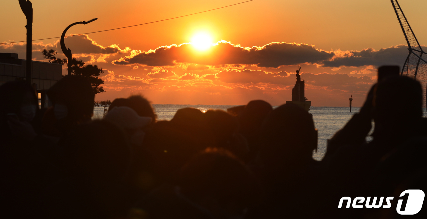 (부산=뉴스1) 여주연 기자 = 1일 오전 부산 해운대해수욕장을 찾은 관광객들이 2021년 첫 해를 바라보고 있다. 이날 신종 코로나 바이러스 감염증(코로나19) 확산 방지를 위해 …