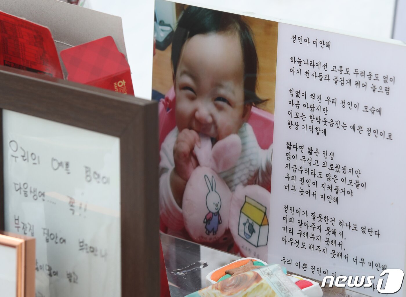 본문 이미지 - 13일 오후 경기 양평군 하이패밀리 안데르센 공원묘원에 양부모의 학대로 숨진 16개월 영아 정인&#40;가명&#41;양의 사진이 놓여 있다. 서울남부지법 형사13부는 이날 아동학대처벌법 위반&#40;아동학대치사&#41; 등 혐의로 구속기소된 정인이의 양모 장모씨와 아동복지법 위반&#40;아동유기·방임&#41; 등 혐의를 받는 양부 안모씨의 첫 공판을 열었다. 2021.1.13/뉴스1 ⓒ News1 송원영 기자