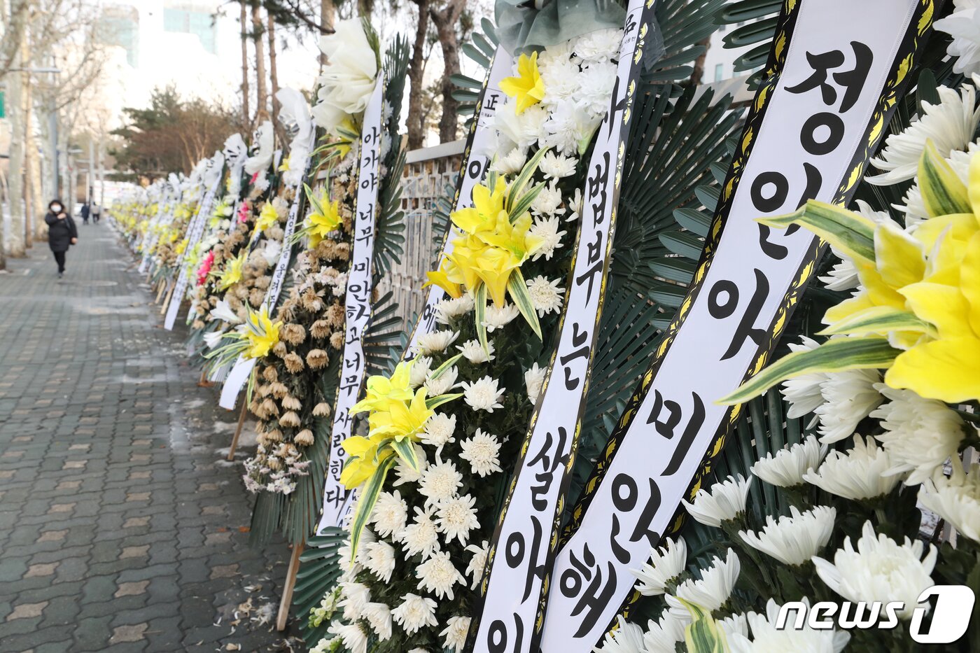 본문 이미지 - 정인양을 입양한 후 수개월간 학대해 사망에 이르게 한 혐의를 받는 양부모에 대한 첫 재판이 열린 13일 오후 서울 양천구 서울남부지방법원 앞에 정인이를 추모하는 조화가 줄지어 있다.  2021.1.13/뉴스1 ⓒ News1 이승배 기자