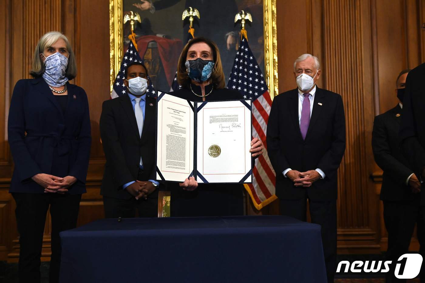 본문 이미지 - 낸시 펠로시 미국 하원의장(가운데)이 지난 13일(현지시간) 본회의를 통과한 도널드 트럼프 대통령 탄핵소추안에 서명한 뒤 취재인 앞에 들어보이고 있다. ⓒ AFP=뉴스1