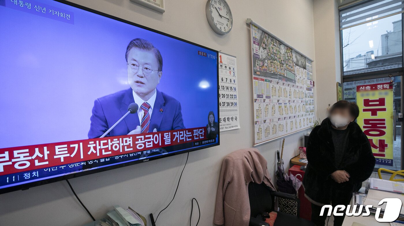 본문 이미지 - 18일 오전 서울 시내의 한 공인중개사 사무소에서 부동산 업자가 문재인 대통령 신년 기자회견 생중계 방송을 지켜보고 있다. 청와대 춘추관에서 열린 이번 기자회견은 사회적 거리두기를 고려해 문재인 대통령 취임 후 처음으로 온·오프라인 화상 연결 방식으로 개최됐다. 2021.1.18/뉴스1 ⓒ News1 이승배 기자