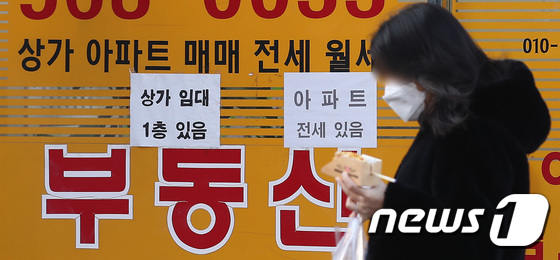서울 시내의 공인중개사 사무소 앞을 한 시민이 지나고 있다. © News1 임세영 기자