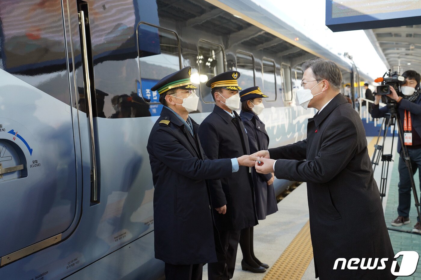 본문 이미지 - 문재인 대통령이 4일 강원도 원주역에서 열린 저탄소·친환경 고속열차 KTX-이음(EMU-260) 개통식에서 열차 운행 신고한 전성수 기장에게 열차 마스터키를 전달하고 있다. 2021.1.4/뉴스1 ⓒ News1 박정호 기자