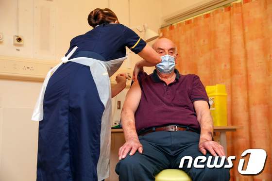 4일(현지시간) 영국 옥스퍼드에 있는 처칠 병원에서 82세 할아버지가 옥스퍼드대·아스트라제네카가 공동개발한 코로나19 백신을 처음으로 접종받고 있다. © AFP=뉴스1 © News1 우동명 기자