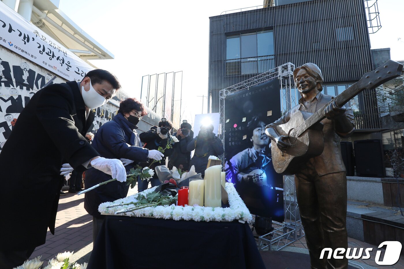 본문 이미지 - '영원한 가객' 고(故) 김광석(1964∼1996)의 25주기인 6일 오후 대구 중구 대봉동 김광석길에서 열린 추모식에서 류규하 대구 중구청장(왼쪽)과 김광석의 부인 서해순 위드삼삼뮤직 대표가 헌화하고 있다. 2021.1.6/뉴스1 ⓒ News1 공정식 기자