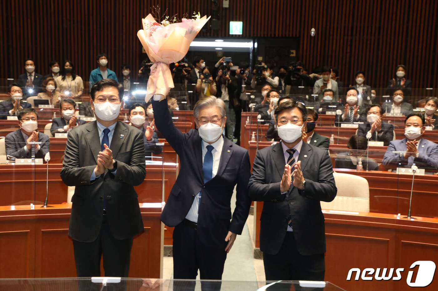 본문 이미지 - 더불어민주당 대선 후보인 이재명 경기도지사가 15일 오전 서울 국회에서 열린 더불어민주당 의원총회에 참석, 윤호중 원내대표가 준 꽃다발을 들어보이며 대선 승리를 다짐하고 있다. 2021.10.15/뉴스1 ⓒ News1 이동해 기자