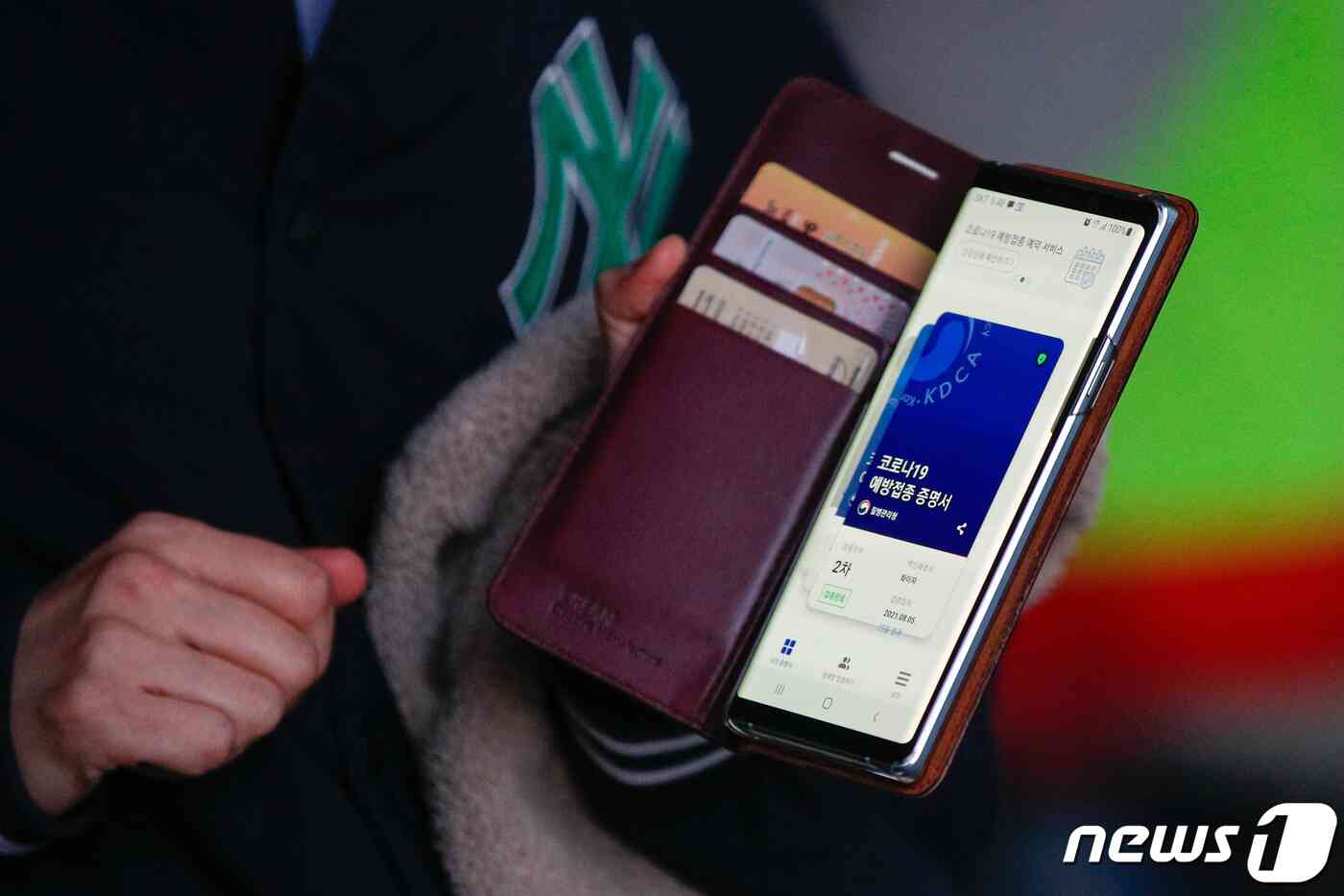 코로나19 방역지침 조정으로 프로야구 경기 관중 입장이 재개된 19일 오후 서울 송파구 잠실야구장에서 관중들이 키움과 LG의 경기를 보기 위해 입장하기 전 백신접종 증명서를 보여주고 있다. 정부는 이번주부터 거리두기 4단계 지역에서 백신 접종 완료자에 한해 실내 경기 최대 20%, 실외 30% 관중 입장을 허용했다. 안은나 기자