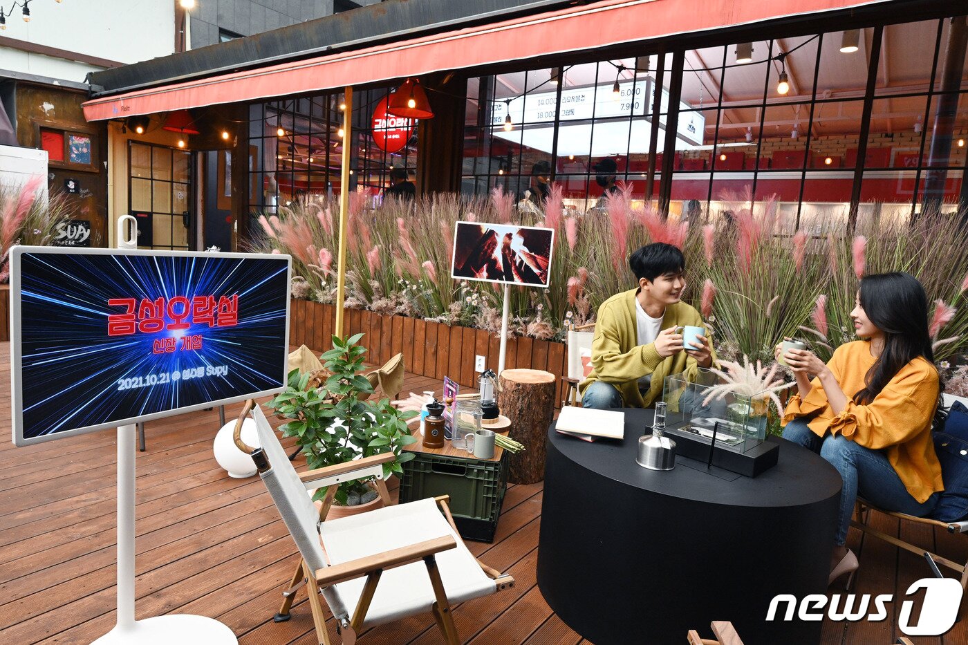 본문 이미지 - 모델들이 서울 성수동 '금성오락실'에서 LG 스탠바이미를 활용한 라이프스타일 체험존에서 제품을 경험하고 있다. (LG전자 제공)ⓒ 뉴스1