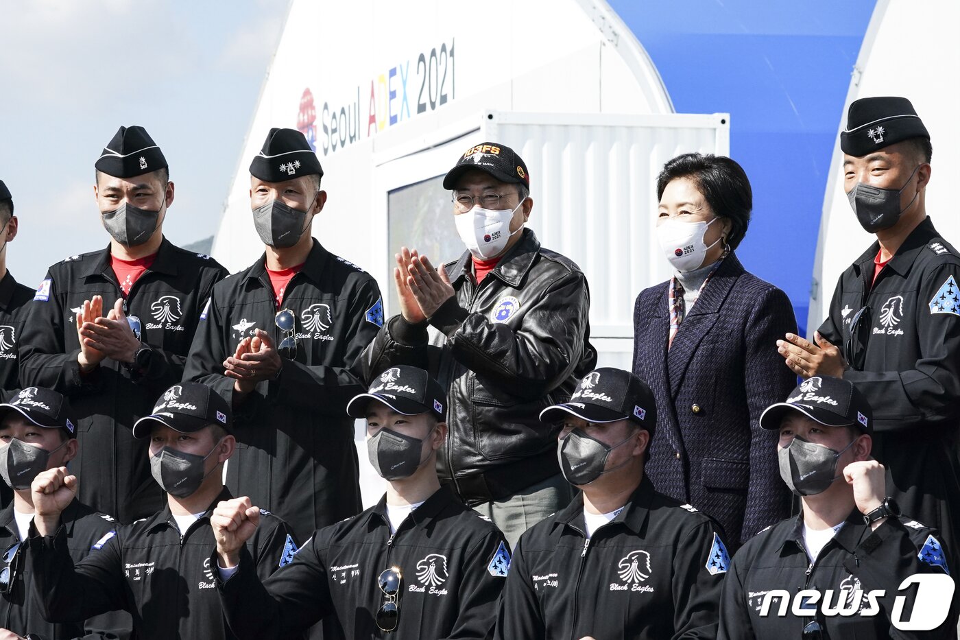 본문 이미지 - 문재인 대통령과 김정숙 여사가 20일 경기도 성남시 서울공항에서 열린 2021 서울 국제 항공우주 및 방위산업 전시회(ADEX) 개막 기념행사에 참석해 시범비행을 마친 공군 특수비행팀 블랙이글스 대원들과 기념촬영을 하고 있다. 2021.10.20/뉴스1 ⓒ News1 이광호 기자