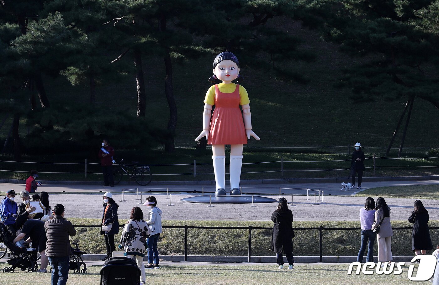 본문 이미지 - 25일 오후 서울 송파구 올림픽공원 야외 88잔디마당에 설치된 넷플릭스 드라마 ‘오징어게임’ 영희 로봇 동상이 시민들 눈길을 끌고 있다. 올림픽공원은 “오늘부터 약 3개월간 영희 로봇 동상을 전시할 예정”이라고 밝혔다. 4m 높이의 영희 동상에서는 ‘오징어게임’ OST와 함께 ‘무궁화 꽃이 피었습니다’라는 드라마 속 음성도 나온다. 2021.10.25/뉴스1 ⓒ News1 박세연 기자